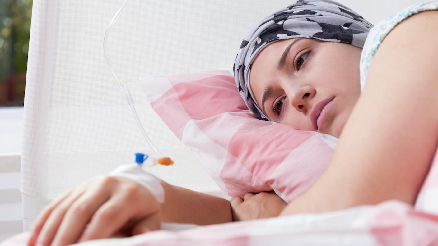 Woman lying in bed and receiving cancer treatment through an IV